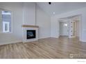 Open living room featuring a modern fireplace with white stone and light wood mantel at 497 Muirfield Cir, Louisville, CO 80027