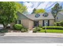 Charming brick home with dormer windows and lush landscaping in a well-manicured yard at 7190 S Poplar Ct, Centennial, CO 80112