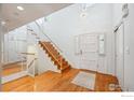 Bright foyer with hardwood floors, grand staircase, and abundant natural light from clerestory windows at 7190 S Poplar Ct, Centennial, CO 80112