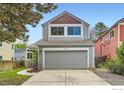 Charming two-story home with gray siding and a two car garage on a sunny day at 744 Owl Dr, Louisville, CO 80027