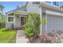Inviting home entrance with a charming front door, a well-maintained lawn, and a two car garage at 744 Owl Dr, Louisville, CO 80027