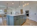 Stylish kitchen island with quartz countertops and stainless steel appliances; an ideal gourmet space at 964 Saint Andrews Ln, Louisville, CO 80027