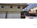 Multi-car garage with light-colored siding under multiple windows offering ample natural light and attached to home at 9848 Lane St, Thornton, CO 80260