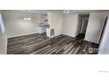 Open-concept living room with kitchen, laminate flooring, and neutral paint, offering versatile living space at 9848 Lane St, Thornton, CO 80260
