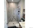 Modern bathroom featuring marble tiled shower with glass door and sleek fixtures at 1225 Ithaca Dr, Boulder, CO 80305