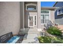 Inviting front entrance with covered porch, decorative columns, and beautiful landscaping at 13311 Pearl Cir, Thornton, CO 80241