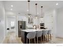 Modern kitchen features stainless steel appliances, a large island, and stylish pendant lighting at 1591 Poplar Dr, Erie, CO 80516