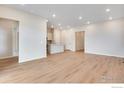 Open-concept living room and kitchen area with recessed lighting and wood flooring at 1760 Mount Meeker Ave, Berthoud, CO 80513