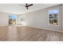 Bright and airy living room featuring wood floors, large windows, and a ceiling fan at 17692 Olive St, Broomfield, CO 80023