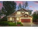 Charming two-story home with a well-manicured lawn and inviting curb appeal at twilight at 301 Widgeon Ln, Longmont, CO 80503