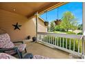 Relaxing front porch with comfortable seating and decorative hanging plants at 301 Widgeon Ln, Longmont, CO 80503