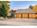 Spacious three-car garage featuring modern glass doors and ample parking space for vehicles and storage at 3746 Wonderland Hill Ave, Boulder, CO 80304