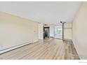 Living room with light wood floor, neutral walls, a ceiling fan, and stainless appliances at 4110 Hale Pkwy # 5F, Denver, CO 80220