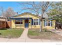 Charming yellow house with blue trim, a welcoming front porch, and a well-maintained lawn at 503 E Oak St, Lafayette, CO 80026
