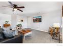 Comfortable living area with carpet, a ceiling fan, and large wall-mounted television at 5425 County Road 32 # 27, Mead, CO 80504
