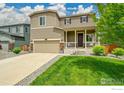 Charming two-story home with a well-maintained lawn and welcoming front porch at 6008 Sandstone Cir, Frederick, CO 80516