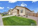 Beautiful home with a well-manicured lawn, attached garage, and charming curb appeal at 7306 Ellingwood Cir, Frederick, CO 80504