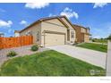 Well-maintained home featuring an attached garage, green lawn, and attractive exterior paint scheme at 7306 Ellingwood Cir, Frederick, CO 80504