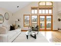 Bright living room featuring a vaulted ceiling, large windows, and access to an outdoor deck at 990 Utica Cir, Boulder, CO 80304