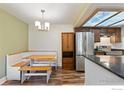 Bright kitchen features a stainless steel refrigerator, dark wood cabinets, and eat-in dining area at 10890 W Evans Ave # 1G, Lakewood, CO 80227