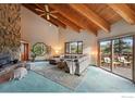 Bright living room features vaulted ceilings, exposed beams, a stone fireplace, and scenic views at 1101 Peakview Cir, Boulder, CO 80302