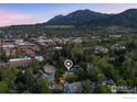Stunning aerial view of the property nestled among trees with mountain views at 1133 Mapleton Ave, Boulder, CO 80304