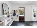 Bright entryway with a stained wood door, white shelving, and views of the exterior at 1245 Longs Peak Ave, Longmont, CO 80501