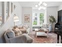 Cozy living room featuring neutral tones, comfortable sofas, and a window seat bathed in natural light at 1245 Longs Peak Ave, Longmont, CO 80501