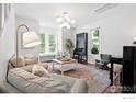 Inviting living room with comfortable seating, a stylish light fixture, and ample natural light at 1245 Longs Peak Ave, Longmont, CO 80501
