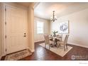 Bright dining room featuring a chandelier, an accent rug, a modern painting, and a hardwood floor at 1358 14Th Ave, Longmont, CO 80501