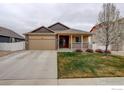 Charming single-Gathering home with a well-maintained lawn, front porch, and two-car garage on a cloudy day at 1540 Murrlet St, Berthoud, CO 80513