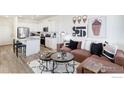 Stylish living space with white walls, modern art, and comfortable seating next to the open kitchen at 18714 E 99Th Ave, Commerce City, CO 80022