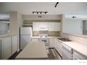 Bright kitchen with white appliances, an island, and ample counter space at 2162 Concord Ln, Superior, CO 80027