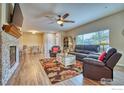 Open-concept living room featuring a stone fireplace, dining area, and comfortable seating at 2417 Calais Dr # 19 D, Longmont, CO 80504