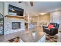 Relaxing living room with a stone fireplace, television, and adjacent kitchen area at 2417 Calais Dr # 19 D, Longmont, CO 80504