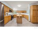 Spacious kitchen with stainless steel appliances, wooden cabinets, and a center island at 2437 Maplewood E Cir, Longmont, CO 80503