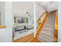 Open-concept living room with stairs, hardwood floors, and lots of natural light at 2437 Maplewood E Cir, Longmont, CO 80503