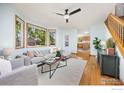Bright living room with large windows, hardwood floors, and a comfortable sectional sofa at 2437 Maplewood E Cir, Longmont, CO 80503