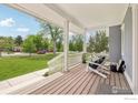 Inviting front porch with wood flooring, white columns, railings and comfortable seating to enjoy the view at 2917 13Th St, Boulder, CO 80304