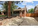 Quaint brick home with a covered front porch, a mature tree, and a concrete driveway at 3039 W Denver Pl, Denver, CO 80211