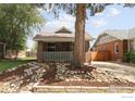 Charming brick home featuring a covered front porch, complemented by lush landscaping and stone accents at 3039 W Denver Pl, Denver, CO 80211