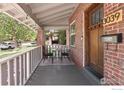 Inviting front porch with seating area, brick columns, and views of the street at 3039 W Denver Pl, Denver, CO 80211