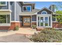 Welcoming home entrance featuring double doors, brick accents, and well-maintained landscaping at 3159 Nelson Rd, Longmont, CO 80503