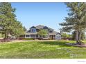 Charming two-story home with manicured lawn, mature trees, and brick accents at 3159 Nelson Rd, Longmont, CO 80503