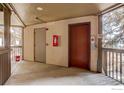 Apartment hallway with doors, concrete floor, and fire safety equipment at 400 Emery St # 208, Longmont, CO 80501
