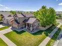 Aerial view of a charming home, showcasing its well-manicured lawn, mature trees, and close neighborhood at 548 Mathews Cir, Erie, CO 80516
