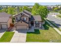 Aerial view of a charming home, showcasing its well-manicured lawn, mature trees, and proximity to the neighborhood at 548 Mathews Cir, Erie, CO 80516