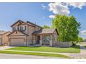 Charming two-story home with a well-maintained lawn, inviting front porch and an attached two car garage at 548 Mathews Cir, Erie, CO 80516