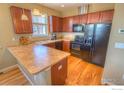 Well-equipped kitchen featuring wooden cabinets, laminate countertops, and modern black appliances at 705 Rawlins Way, Lafayette, CO 80026