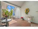 Cozy covered patio featuring comfortable seating, charming decor, and natural light at 8200 S Locust Way, Centennial, CO 80112